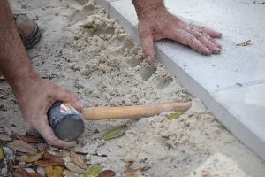 you can use the end of your mallet to push sand underneath to make it even_small