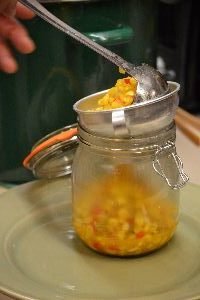 use a ladle and a funnel to place the corn relish into jars_small