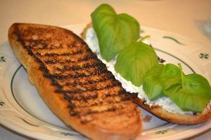 Grilled_bread_with_goat_cheese_and_basil_leaves._small